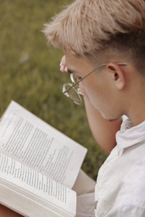 玻璃阅读书的年轻人在公园 · 免费素材图片