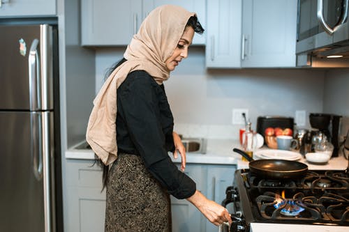 族裔女人在炉子上切换的头巾 · 免费素材图片