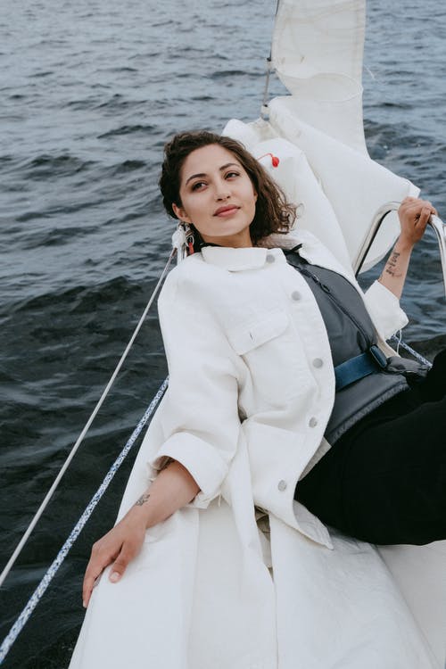 坐在船上的白色长袖衬衫的女人 · 免费素材图片