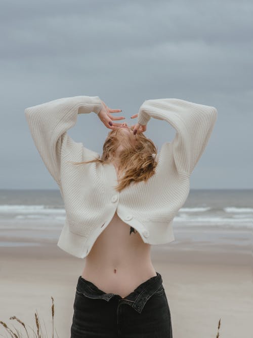 裸露的肚子在海滩上变得面目全非的性感女人 · 免费素材图片