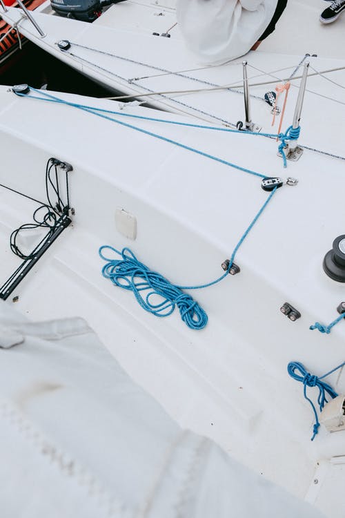 白色纺织品上的蓝色和银色安全别针 · 免费素材图片