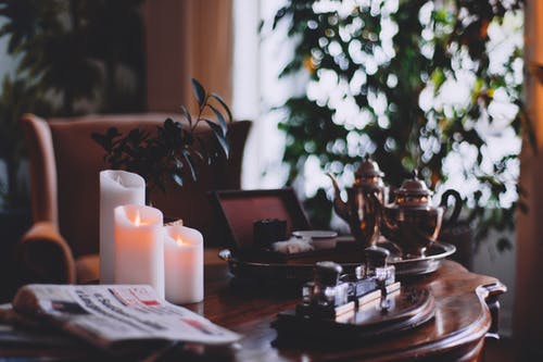 报纸附近燃烧的蜡烛，在家里木制的桌子上 · 免费素材图片