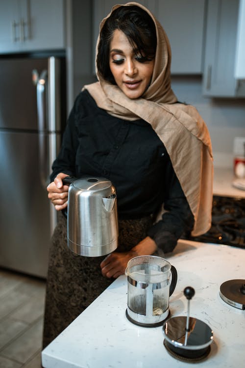 拿着不锈钢容器的黑夹克的女人 · 免费素材图片