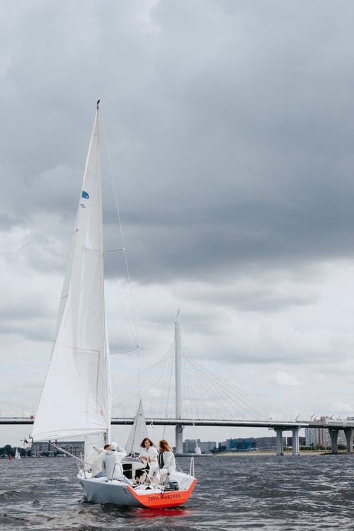 白色帆船在海上，在灰色的天空下 · 免费素材图片