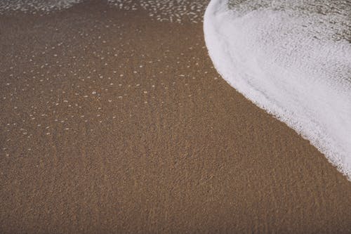 沙滩与泡沫海洋水在日光下 · 免费素材图片