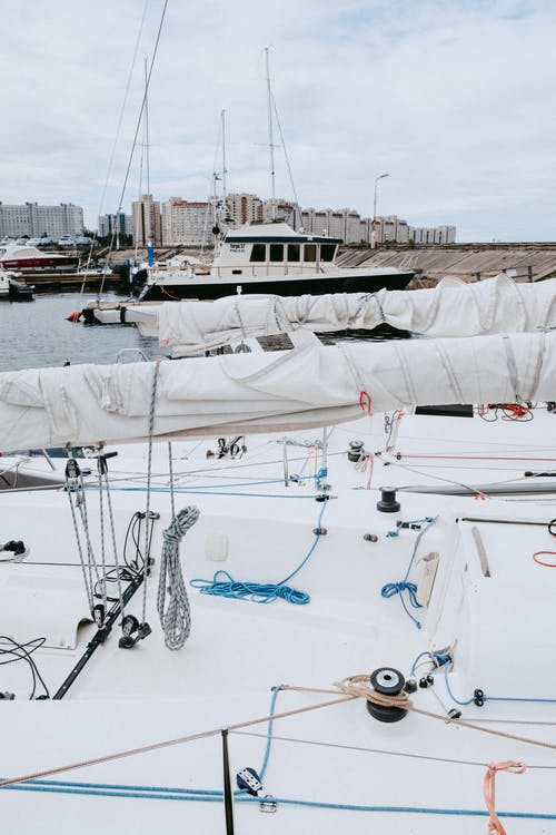 白色和蓝色帆船在海上码头 · 免费素材图片