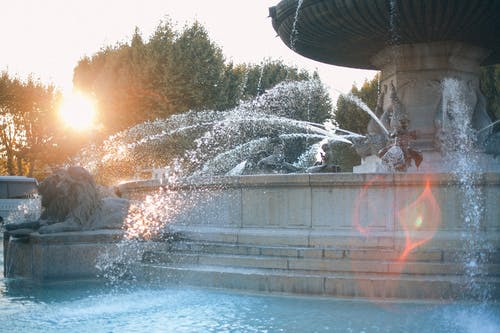 在阳光明媚的公园观赏喷泉 · 免费素材图片