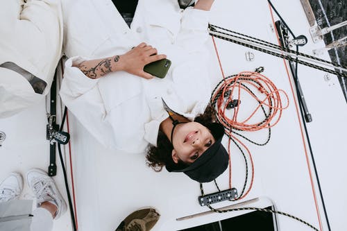 拿着绿色智能手机的白色长袖衬衫的女人 · 免费素材图片