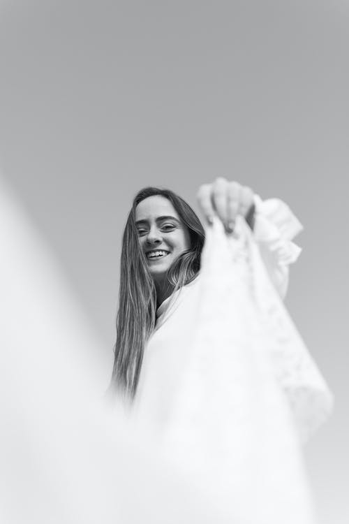女人抱着白色纺织的灰度照片 · 免费素材图片