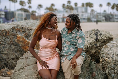 2名穿白色连衣裙的女人坐在岩石上 · 免费素材图片