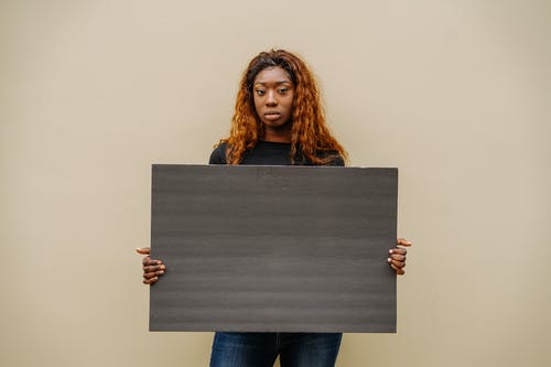 拿着灰色纺织的蓝色牛仔牛仔裤的女人 · 免费素材图片