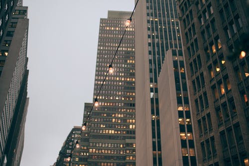 在晚上的闪亮花环附近的现代摩天大楼外墙 · 免费素材图片