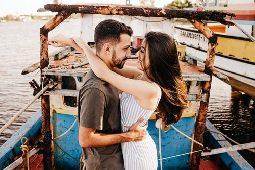 快乐的夫妻，在风化的船上拥抱 · 免费素材图片