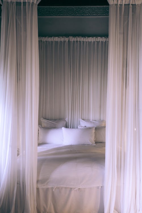 白色半透明顶棚下的舒适床 · 免费素材图片