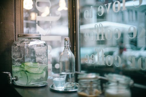 自助餐厅里有玻璃罐黄瓜注入水和一瓶清水 · 免费素材图片