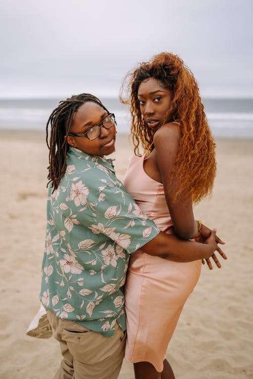 2名妇女在海滩上穿白色绿色和蓝色碎花连衣裙 · 免费素材图片