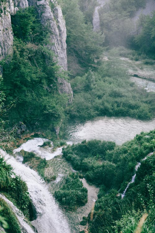在池塘附近的高山上的快速瀑布 · 免费素材图片