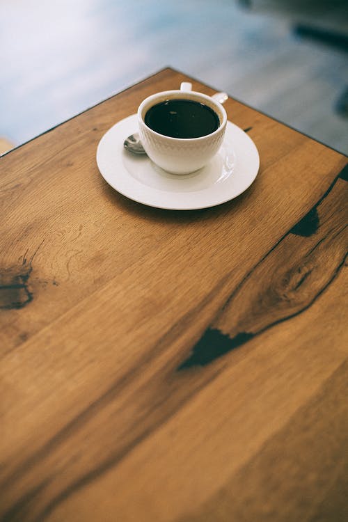 杯咖啡在咖啡馆里的木桌上 · 免费素材图片