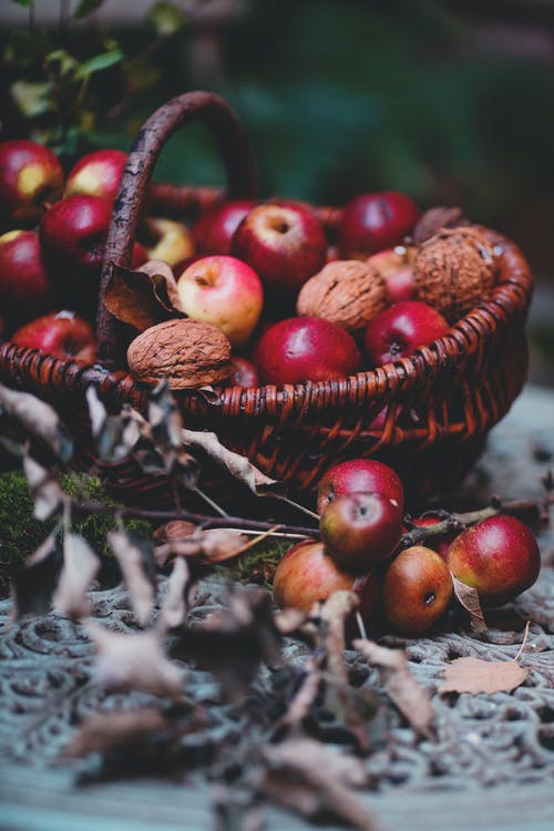 柳条编织的篮子，用成熟的苹果和核桃 · 免费素材图片