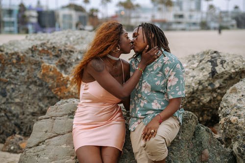 粉色背心的女人亲吻黑色和白色花裙子的女人 · 免费素材图片