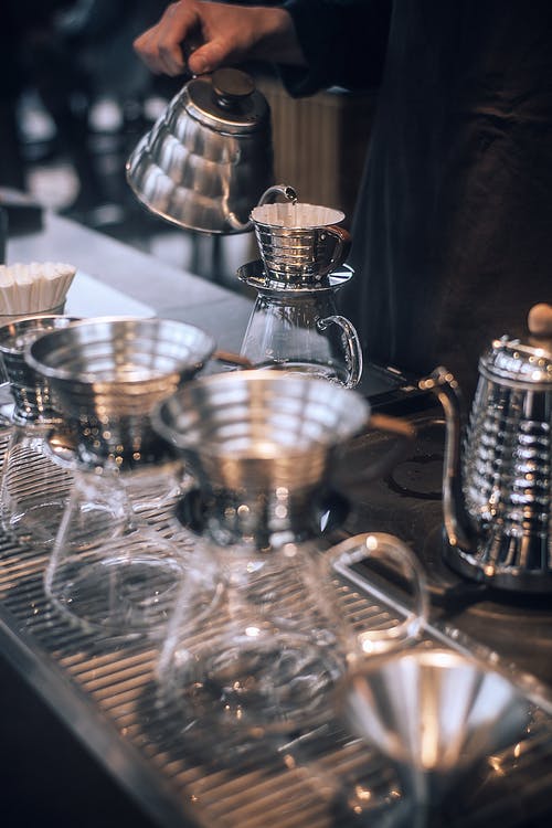 作物咖啡师使用金属壶准备咖啡 · 免费素材图片
