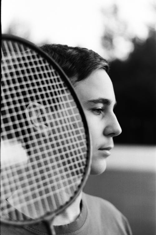 沉思的青少年男孩，在球场上的羽毛球拍 · 免费素材图片