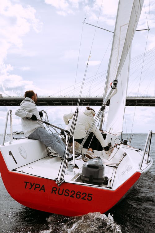 男人和女人骑在白色和红色的船上 · 免费素材图片