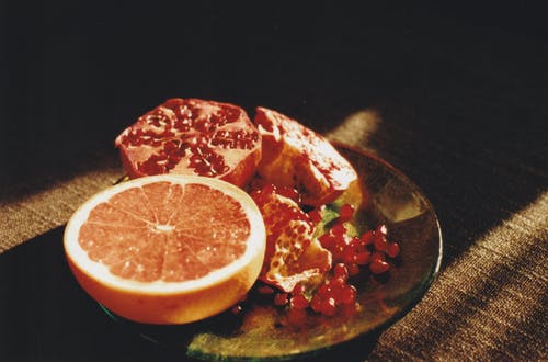 葡萄柚和石榴在盘子上 · 免费素材图片