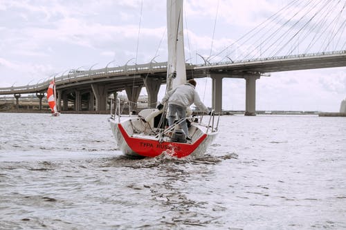 白色和红色的小船，在洁白的天空下海上 · 免费素材图片