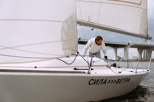 白色的长袖衬衫和黑色的裤子，坐在白船上的人 · 免费素材图片