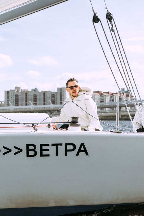 站在白船上的白色礼服衬衫的男人 · 免费素材图片