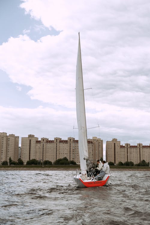 骑在水面上的红色和白色船上的人 · 免费素材图片