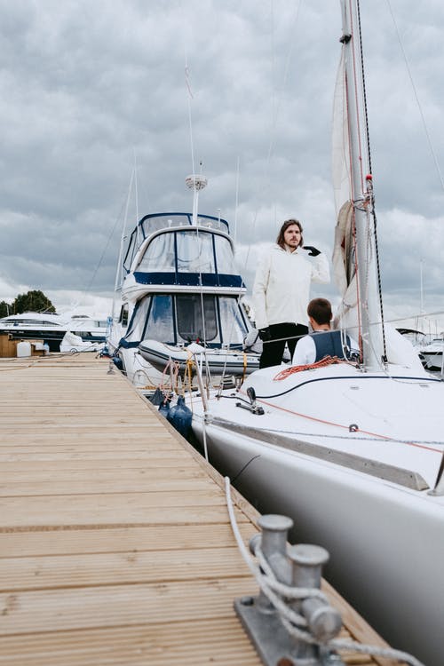 人们在海上码头的白色游艇 · 免费素材图片