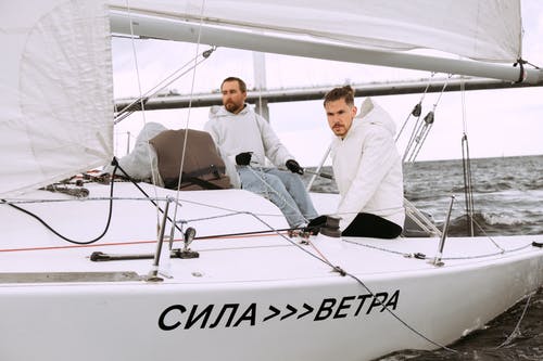 坐在白船上的白衬衫的男人 · 免费素材图片