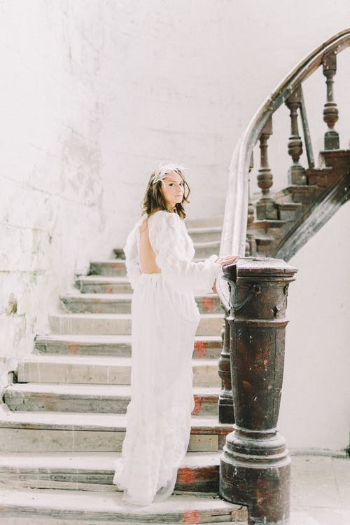 站在楼梯上的白色长袖连衣裙的女人 · 免费素材图片