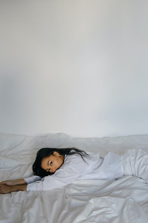 女性亚洲女人躺在舒适的床上 · 免费素材图片