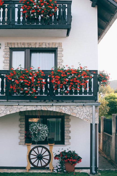 白色的住宅楼，小阳台上装饰着花朵 · 免费素材图片