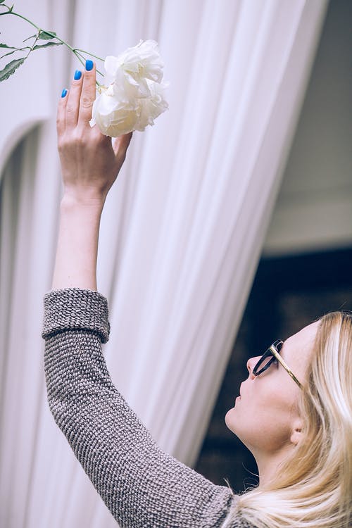 黑色和白色的长袖衬衫，拿着白花的女人 · 免费素材图片