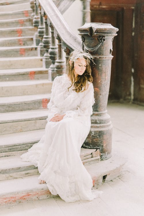 站在灰色的混凝土楼梯上的白色长袖连衣裙的女人 · 免费素材图片