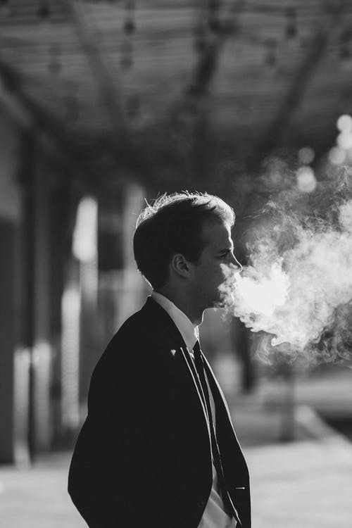 黑色西装外套吸烟的人 · 免费素材图片