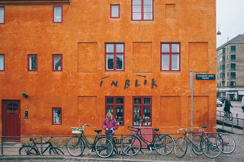 黑色城市自行车停在棕色混凝土建筑旁边 · 免费素材图片