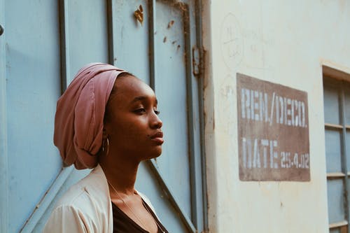 在巨大的旧门旁边的头巾的黑人妇女 · 免费素材图片