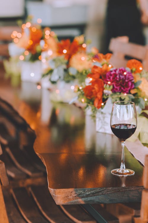 透明红酒杯与棕色木制的桌子上的红酒 · 免费素材图片