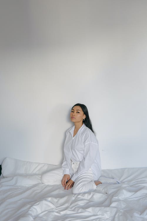 确信年轻亚洲女性在家放松在舒适的床上 · 免费素材图片