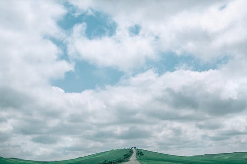 在多云的天空的丘陵山谷中的狭窄路径 · 免费素材图片