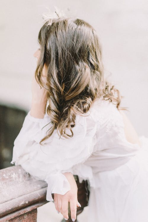 坐在岩石上的白色连衣裙的女孩 · 免费素材图片