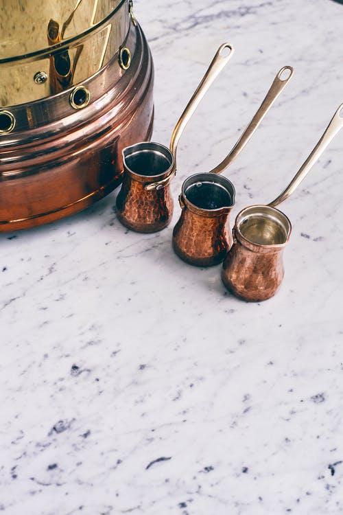 传统的东方咖啡壶和铜火盆放在大理石桌上 · 免费素材图片