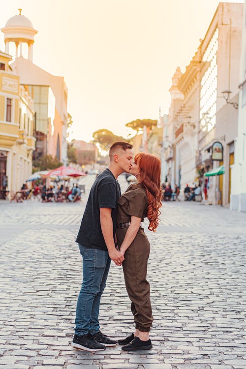 年轻浪漫的情侣，在日落时分在城市的街道上接吻 · 免费素材图片