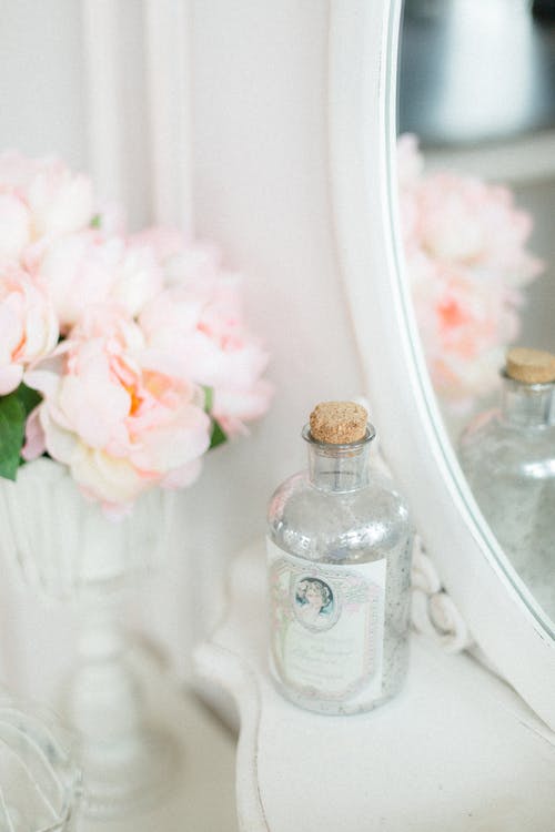 装饰瓶和花瓶与芳香的粉红色花朵，放在白色的桌子上 · 免费素材图片