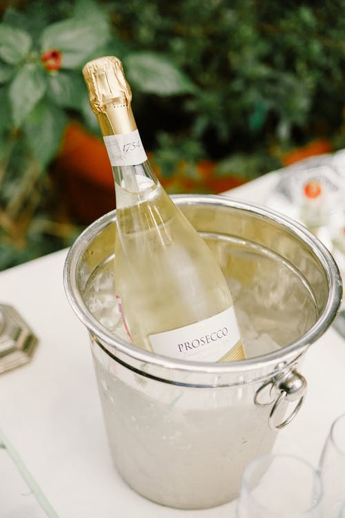 在宴会桌上的冰桶里的香槟酒瓶 · 免费素材图片